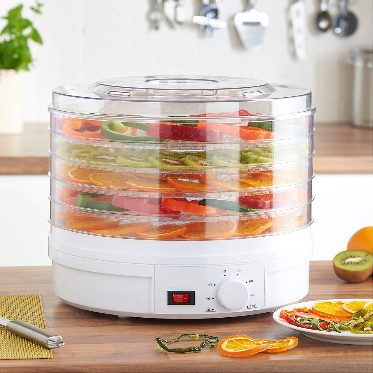 Food dehydrator trays loaded with sliced fruit
