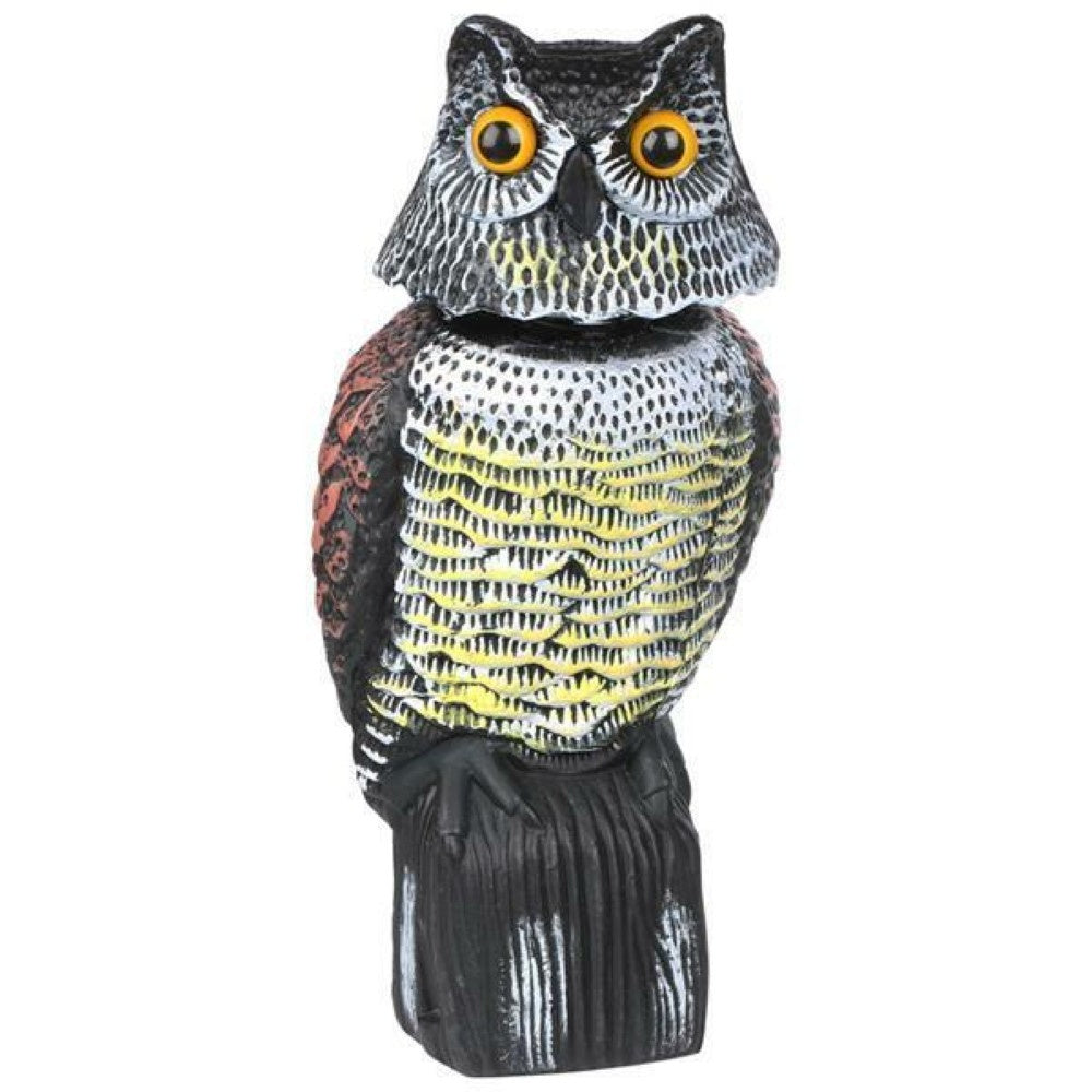 Owl decoy bird scarer standing on garden stake