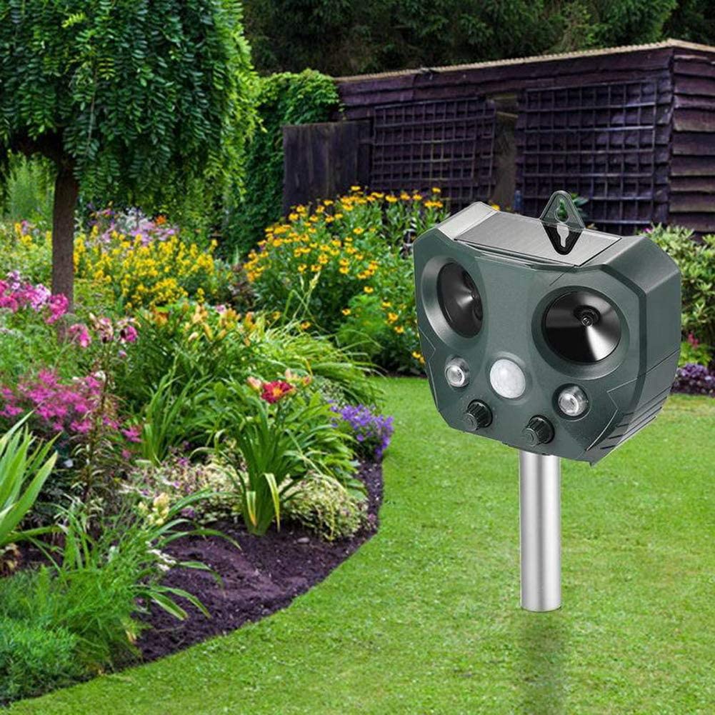 Animal repeller mounted in garden setting
